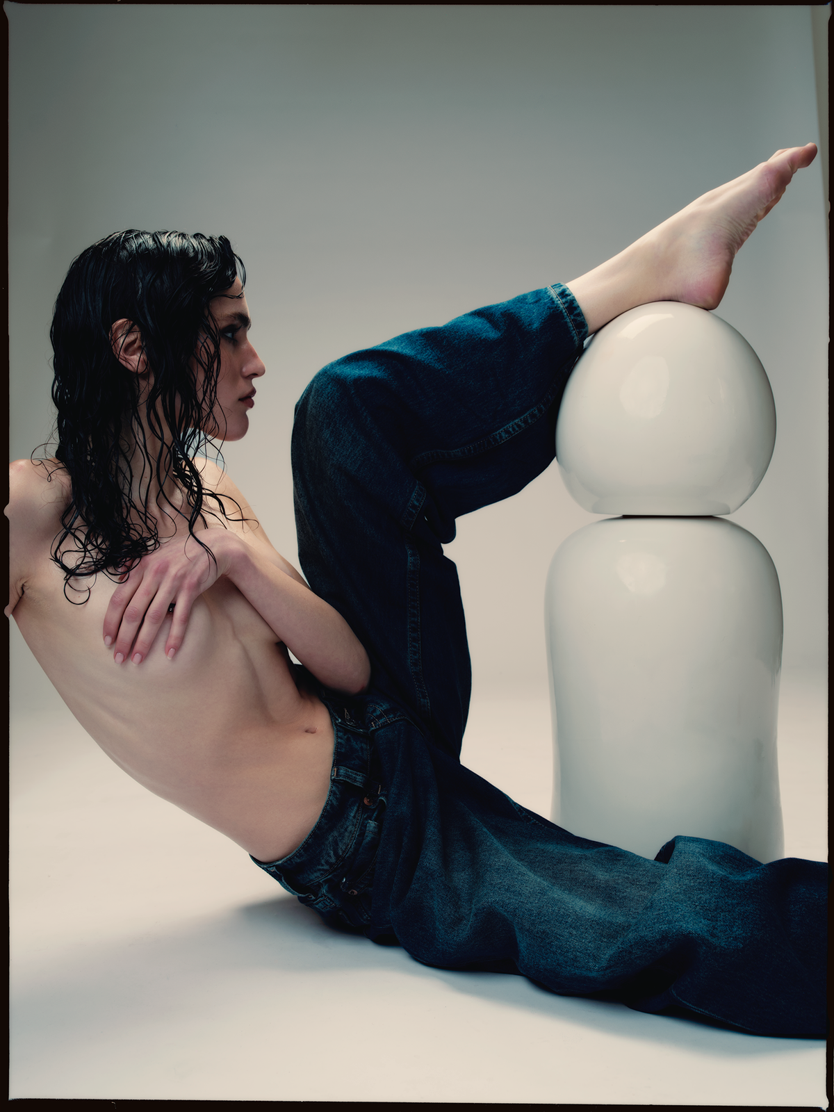 Model in jeans resting her foot on a large Ples'Jour® Opal bottle